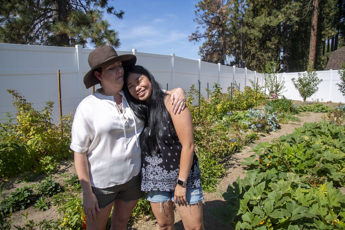 Suzanne Alvarez, who lives in the Colbert area, hugs her daughter, Gabby Alvarez, 20, in their backyard that she turned into a large garden despite never gardening before. Gabby and her three sisters, all adopted from China, help out with the project. It started with rows of raspberries and blueberries, the continued with mixed vegetables and fruit trees. After feeding the local deer, she and her husband added an eight-foot fence around the whole thing.  (Jesse Tinsley/THE SPOKESMAN-REVI)