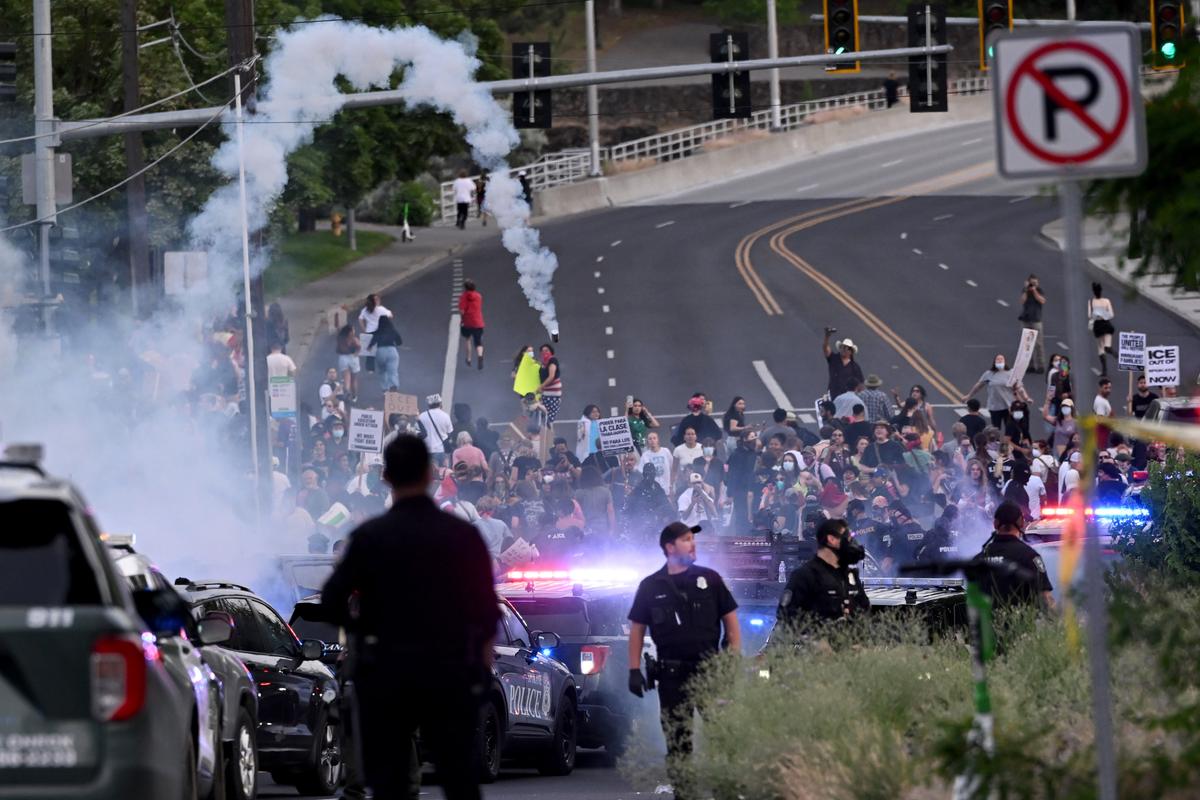 Smoke from canisters begins to drop into a crowd of several hundred who arrived from the “Ice Out” protest held in Riverfront Park that joined the anti-ICE protest around the old Broadview Dairy on the north side of Riverfront Park on Wednesday.  (Jesse Tinsley/THE SPOKESMAN-REVIEW)