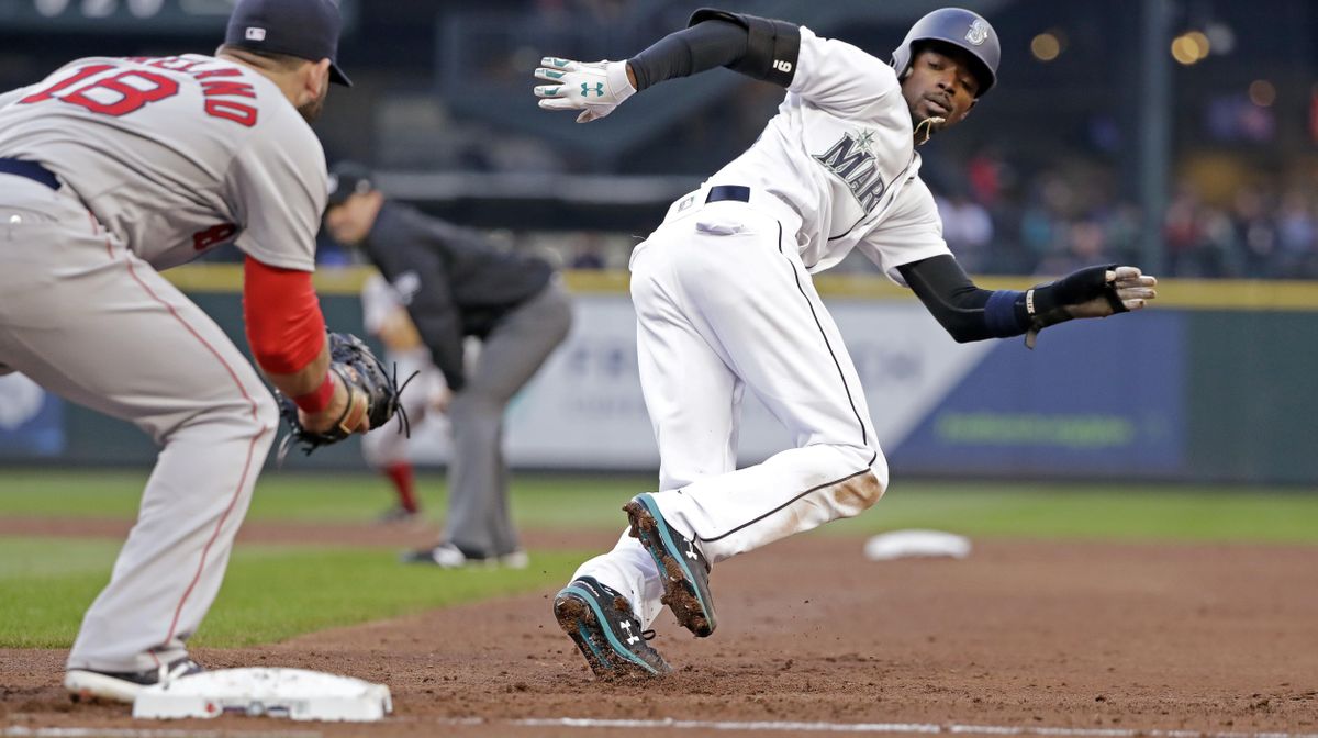 Seattle’s Dee Gordon, right, changes direction and tries to run from first base after being caught off the base on a pickoff attempt, as Boston Red Sox first baseman Mitch Moreland starts toward him during the third inning Thursday in Seattle. Moreland tagged Gordon out on the play. (Elaine Thompson / AP)