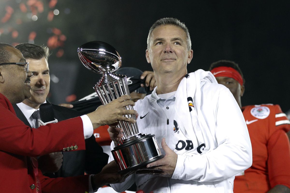 Ohio State coach Urban Meyer, right, holds the trophy after the team