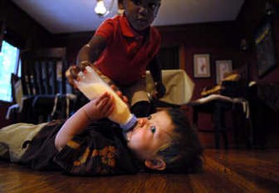 
Ten-month-old Quinn Conner is helped with his bottle by big sister, Saige, during an afternoon feeding. Their mother, Stacey Conner, changed bottles after she learned her old ones might have contained BPA plastic. 
 (Brian Plonka / The Spokesman-Review)