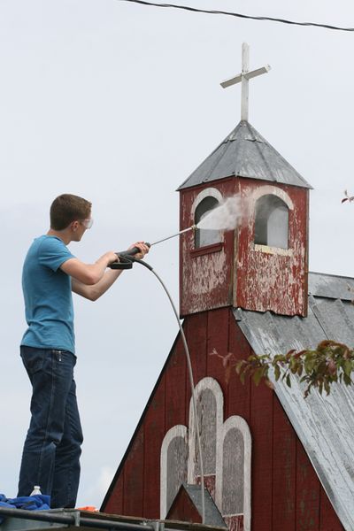 Rob Gaines, 15, washes a small red chapel while volunteering his time during Summer Service Day at the fairgrounds Saturday. (Devin Heilman/press)