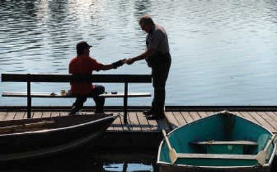 
John McColgin, right, makes a routine and friendly fishing license check with an angler at the Mallard Bay Resort dock on Clear Lake.
 (Rich Landers / The Spokesman-Review)