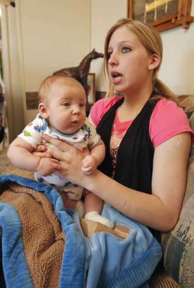 Sarah McKinley, 18, sits with her 3-month-old son Justin on the couch of her mobile home in Blanchard, Okla., on Wednesday. (Associated Press)