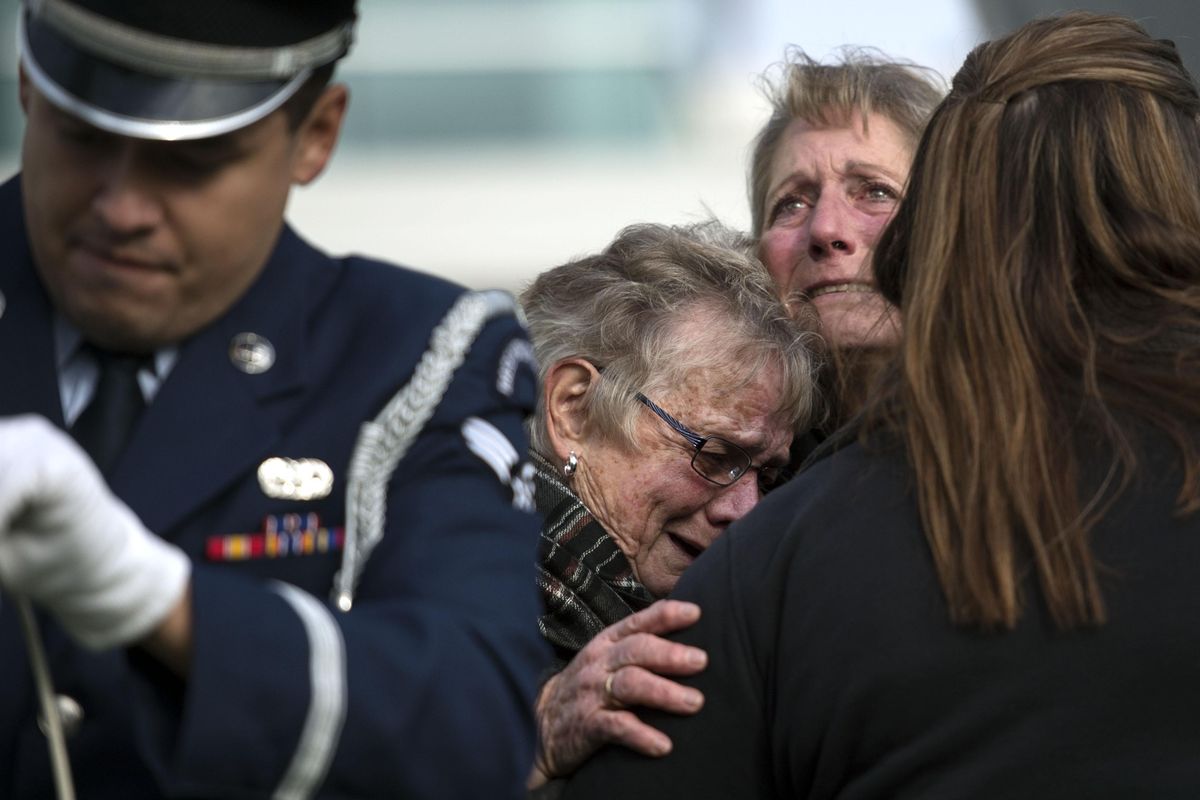 Cathy Baker, center, and her daughter Wendy Herbes cried as a flag was raised in honor of Korean War Veteran Arby Baker during a ceremony at Spokane Veterans Memorial Arena on Friday, November 11, 2016. Arby was Cathy Baker