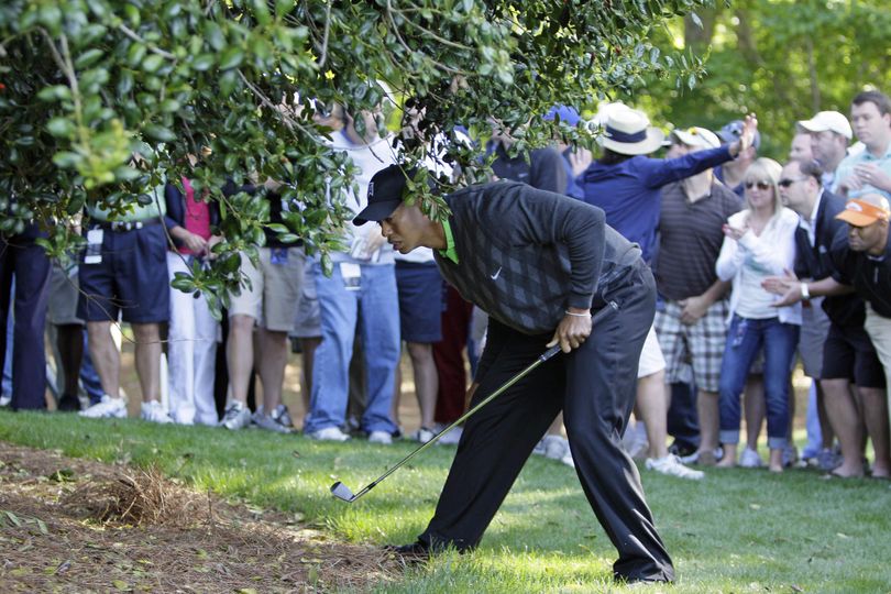Tiger Woods looks for his ball under a tree on the 14th hole during the first round of the Quail Hollow Championship golf tournament at Quail Hollow Club in Charlotte, N.C., Thursday, April 29, 2010. (Gerry Broome / Associated Press)