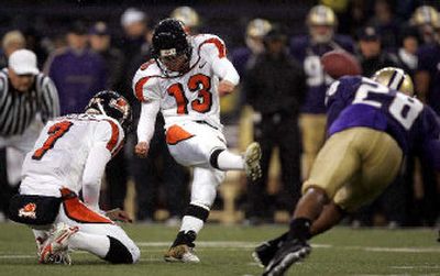 
Oregon State's Alexis Serna kicks the second of two first-half field goals as Washington's Roy Lewis moves in. 
 (Associated Press / The Spokesman-Review)
