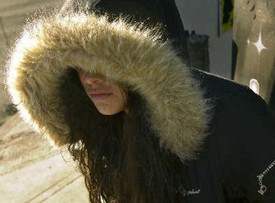 
Wendy Adame, 17, waits for the bus Friday morning on Hamilton Street. Single-digit temperatures felt lower with wind chill. 
 (Kathryn Stevens / The Spokesman-Review)