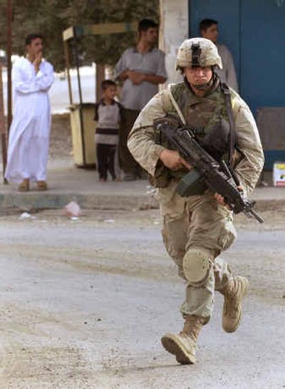 
A U.S. Army soldier runs across an intersection as troops withdraw from central Samarra, Iraq, Tuesday, four days after a joint U.S. and Iraqi military incursion into the city. 
 (Associated Press / The Spokesman-Review)