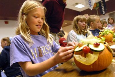 
Bailey Burgin, 9, turns a small pumpkin and a pile of leftover vegetables and rinds into a Halloween decoration during a craft project at Fernan Elementary on Friday. The district's food service program sponsored the craft project to teach kids about eating more vegetables and fruits. 
 (Jesse Tinsley / The Spokesman-Review)