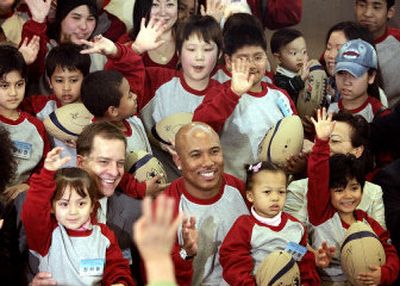 
Pittsburgh Steeler and Super Bowl MVP Hines Ward, bottom line center, waves together with children of mixed racial origins during their meeting in Seoul, Korea, on Saturday.
 (Associated Press / The Spokesman-Review)