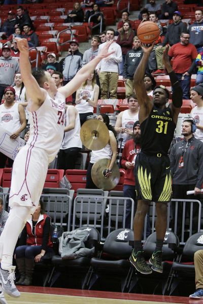 Oregon guard Dylan Ennis shoots while defended by Washington State forward Josh Hawkinson during the second half Saturday in Pullman. Hawkinson was kicked in the groin in the first half, which resulted in the ejection of Oregon’s Dillon Brooks. (Young Kwak / AP)