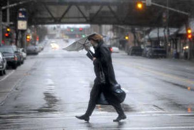 
Wind turns Barbara Greenwood's  umbrella inside out as she hurries across Riverside Avenue in downtown Spokane on Monday. A hazardous weather outlook and wind advisory were posted for the region. 
