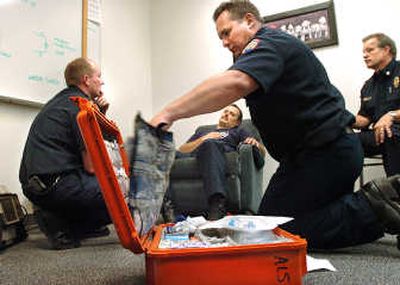 
The Spokesman-Review Paramedic Darrell Core, center, grabs equipment from a case as firefighter Kevin Helt, left, talks with Training Officer Paul Hatten, in chair, and Capt. Tim Cruger, right, during a training session at Fire Station 7.
 (Photos by Joe Barrentine / The Spokesman-Review)