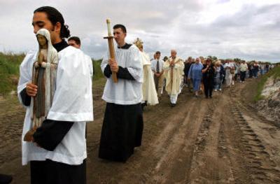 
Chris Ortega, an Ave Maria University student, left, leads a procession March 26, 2004, around the future site of Ave Maria University near Immokalee, Fla. 
 (File Associated Press / The Spokesman-Review)
