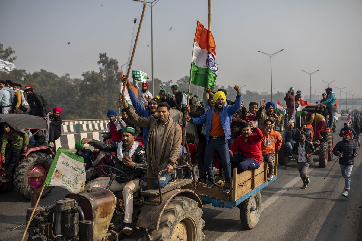 Protesting farmers ride tractors and shout slogans as they march to the capital, breaking police barricades during India’s Republic Day celebrations Jan. 26 in New Delhi, India. (Altaf Qadri)