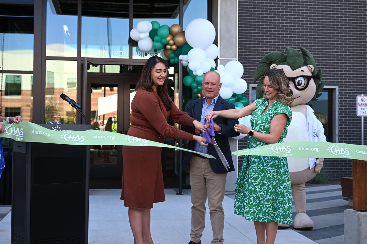 Licett Garbe, Aaron Wilson and Maria Ekkert cut the ribbon on the CHAS Health Learning Institute in the Iron Bridge development in Spokane, Washington Thursday, Aug. 8, 2024. The learning institute will be a training school for people wanting to be medical assistants, pharmacy technicians, dental assistants and other roles in medical care. Garbe is a representative of Senator Patty Murray. Aaron Wilson and Maria Ekkert work for CHAS.  (Jesse Tinsley/THE SPOKESMAN-REVIEW)