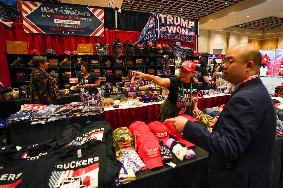 Conference attendees shop for merchandise at a trade show at the Conservative Political Action Conference (CPAC) Friday, Feb. 25, 2022, in Orlando, Fla.  (John Raoux)