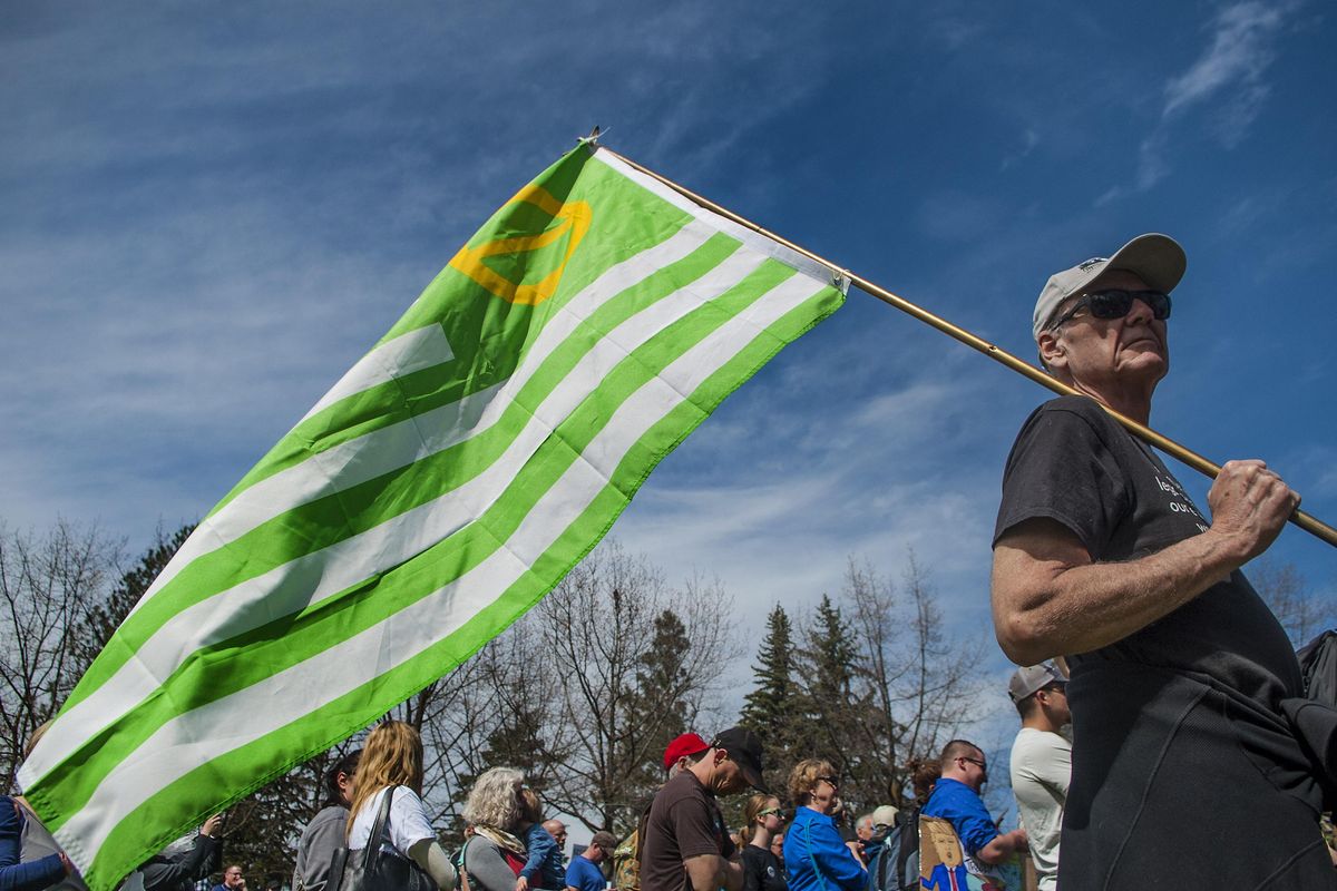 “This is the design of the very first Earth Day flag that was used in 1970,” said David Randall during Science March in Spokane on Saturday, April 22, 2017. (Kathy Plonka / The Spokesman-Review)