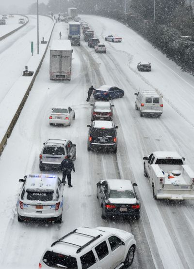 Traffic crawls along Independence Boulevard on Wednesday as a storm hits Charlotte, N.C., on its way to Washington, D.C. (Associated Press)