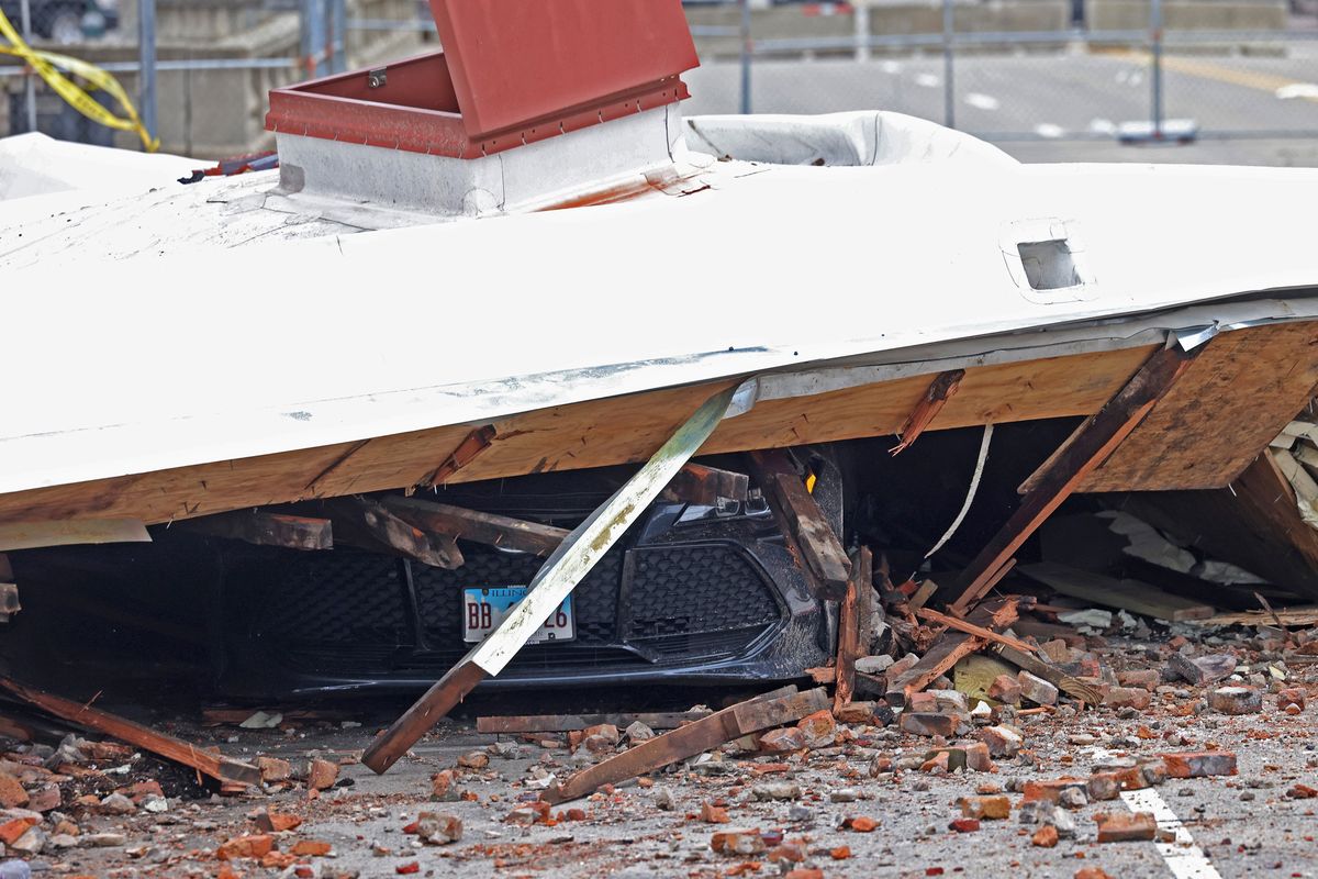 A vehicle is crushed under a blown off roof across the street from the Apollo Theatre on Saturday, April 1, 2023, in Belvidere, Illinois. (John J. Kim/Chicago Tribune/TNS)  (John J. Kim/Chicago Tribune/TNS)