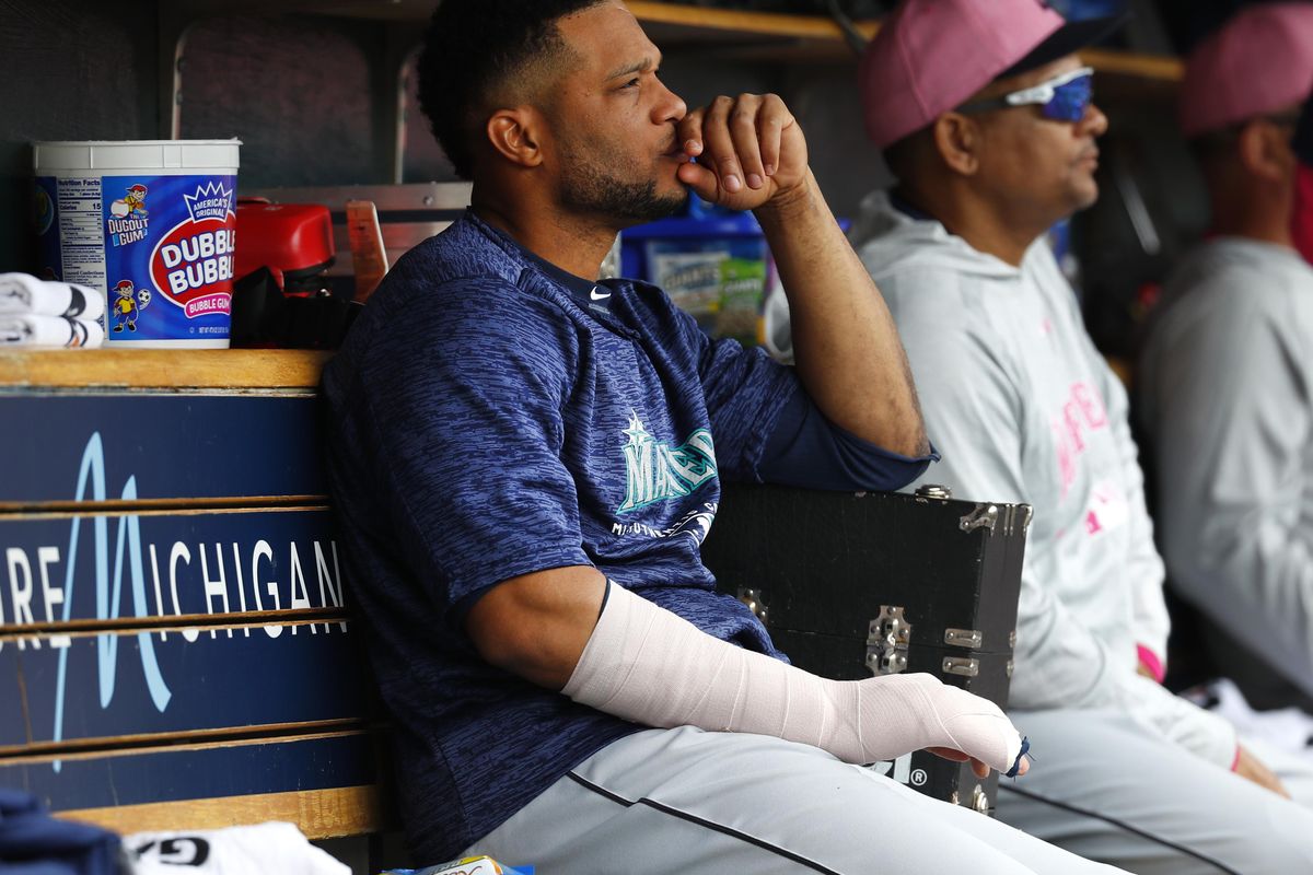 Seattle Mariners’ Robinson Cano sits on the bench with his hand wrapped in the fifth inning of a baseball game against the Detroit Tigers in Detroit, Sunday, May 13, 2018. (Paul Sancya / AP)