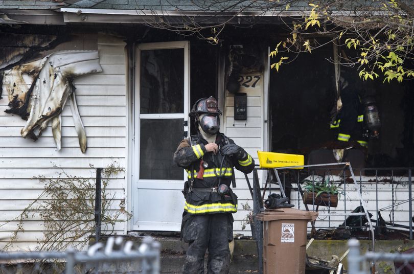 Spokane Fire Department crews work the scene of a fatal house fire at 1227 E. Longfellow Ave. on Tuesday morning. (Dan Pelle)