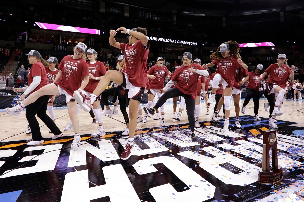 Stanford head coach Tara VanDerveer center, joins her players in a dance behind the regional trophy after they beat Texas 59-50 in a college basketball game in the Elite 8 round of the NCAA tournament, Sunday, March 27, 2022, in Spokane, Wash.  (Young Kwak)
