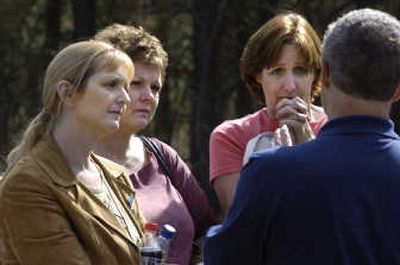
From left, Meloney Hall and her sisters Michele Harrison and Marcia Bryan listen Thursday to Deputy Tom Walker of the Spokane County Sheriff's Office brief them about developments concerning Hall's missing daughter, Amy Wheelock.  They were gathered at Dragoon Creek Campground in north Spokane County. 
 (Photos by DAN PELLE / The Spokesman-Review)