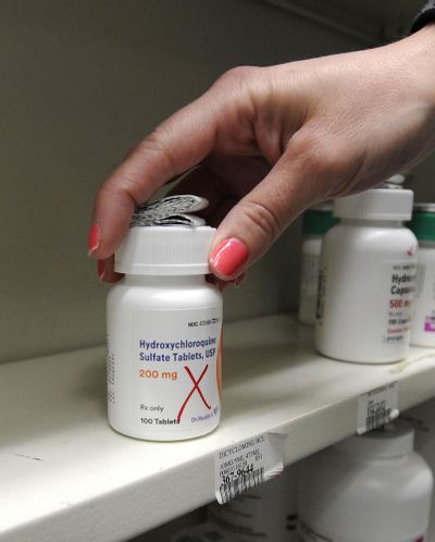 Pharmacist Amanda Frank reaches for a bottle of Hydroxychloroquine at the Medicine Shoppe on Hazle Street in Wilkes-Barre, Pa., Tuesday, March 31, 2020. (Mark Moran / The Citizens' Voice via AP)