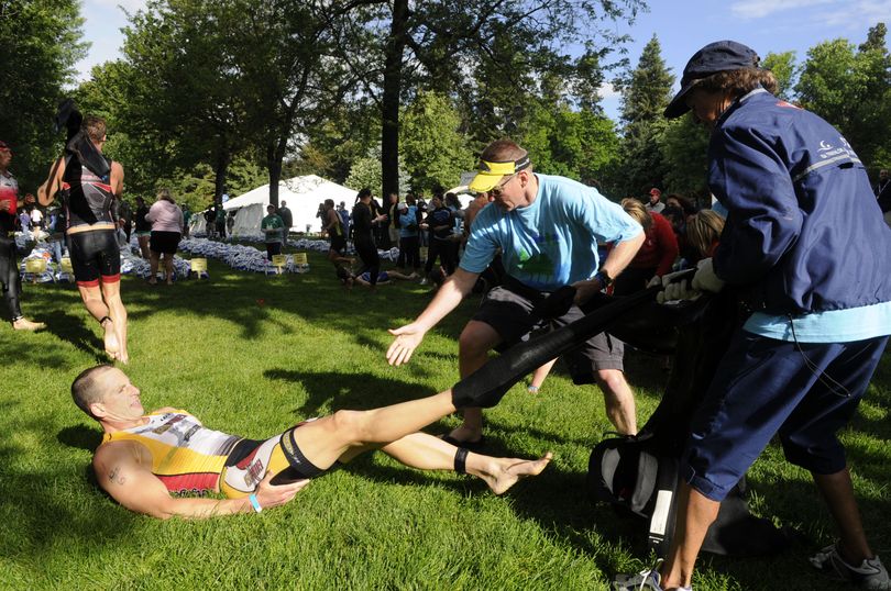 Dennis Melowski of Kohler, Wisc., has his wetsuit removed with the help of the volunteers after he swam the 2.4 miles at the start of the Ford Ironman Coeur d'Alene, June 21, 2009. (Dan Pelle / The Spokesman-Review)