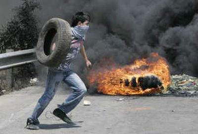 
A Hezbollah supporter burns tires, closing the highway to Lebanon's international airport during a protest in Beirut. Associated Press
 (Associated Press / The Spokesman-Review)