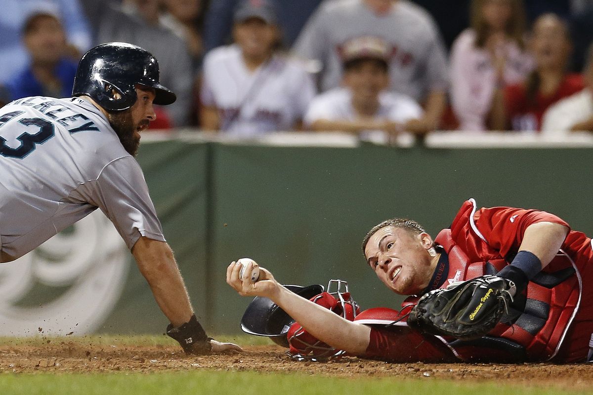 Boston Red Sox catcher Christian Vazquez has the ball, but not the out, after Mariners