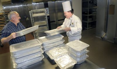 Maurice Smith, left, the executive director of Feed Spokane, gets help from Davenport Hotel banquet chef Bryan Franz as he picks up leftover food from a recent weekend.  (Christopher Anderson / The Spokesman-Review)