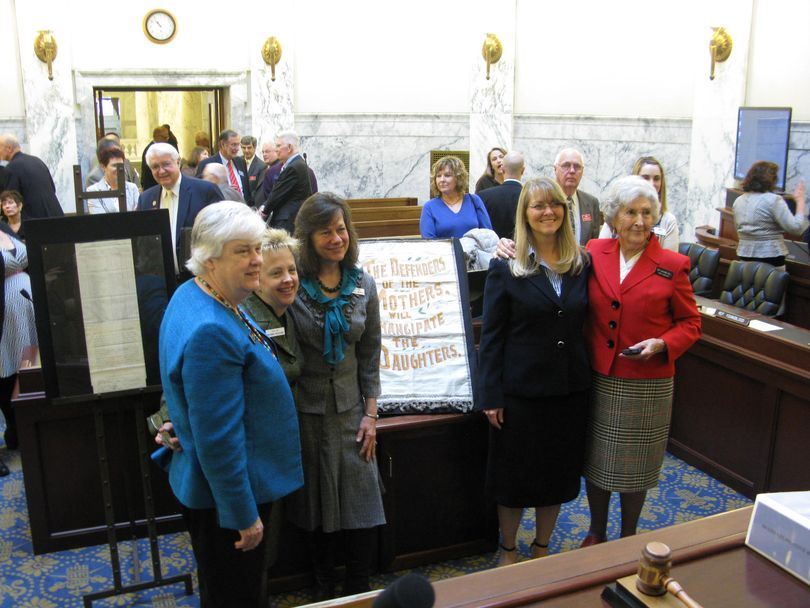 Female members of the Joint Finance-Appropriations Committee pose for a photo with historic artifacts from when Idaho became the 4th state to grant women the right to vote, in 1896. (Betsy Russell)