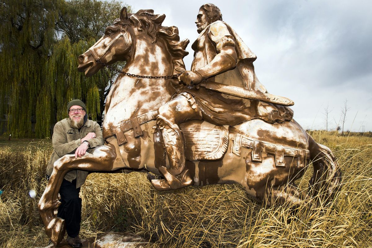 Mike Fureguson, owner of Way Out West, stands next to one of the may statuary he sells on his property at 11610 White Road. This one he believes is of actor Charlton Heston from the 1961 historical epic movie “El Cid.” (Colin Mulvany / The Spokesman-Review)
