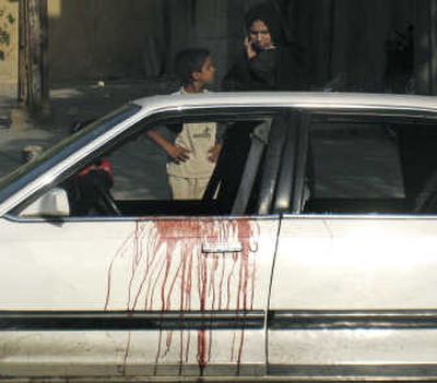 
A woman and a child inspect a car with blood splattered on the door after two Christian Iraqi women were shot to death in Baghdad on Tuesday. Associated Press
 (Associated Press / The Spokesman-Review)