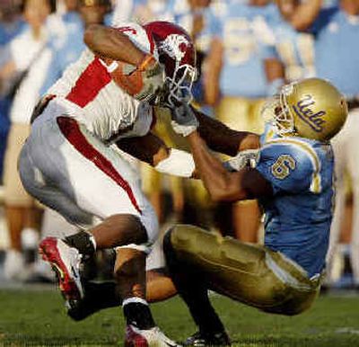 UCLA's Matt Clark brings down WSU running back Jerome Harrison by the facemask, though no penalty was called.
(Associated Press / The Spokesman-Review)
