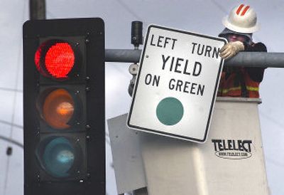 
Spokane County employee Shawn Mackin adjusts the left turn sign while making a revision to the traffic signal at Gillis and Sprague in Spokane Valley. 
 (Liz Kishimoto / The Spokesman-Review)