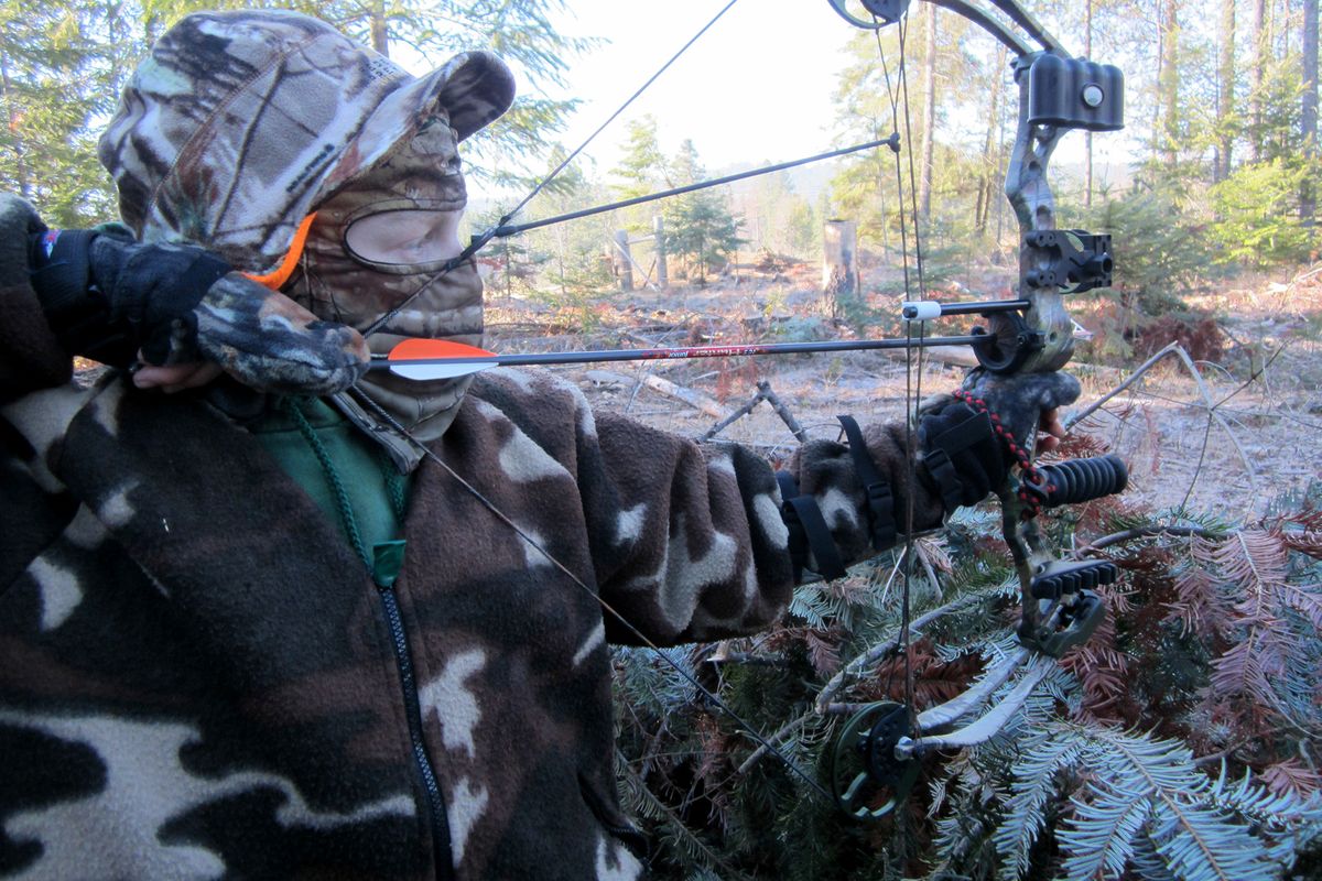 Carsen Smith draws his bow on a father- son outing during the Washington wild turkey hunting season in 2013. (Courtesy Photo / The Spokesman-Review)