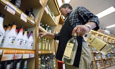 Bill Oldenburg stacks shelves at a Seattle state-run liquor store.  The state is moving aggressively to capitalize on liquor sales.  (Associated Press / The Spokesman-Review)