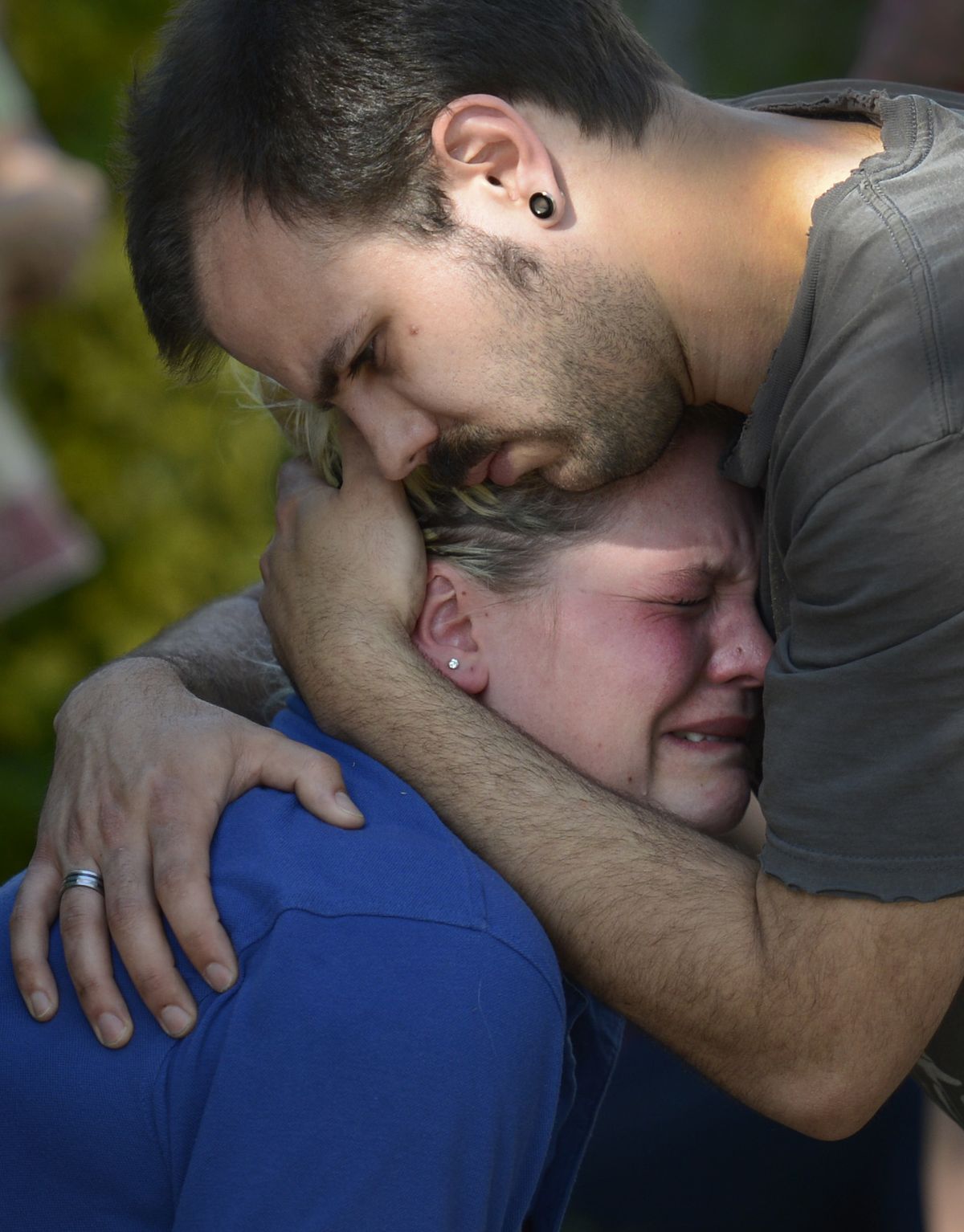 Nick Peraud consoles his fiancee, Skye Foster, as Spokane firefighters battle a blaze that consumed their residence on the 1200 block of East Nora Avenue in Spokane on Wednesday. (Colin Mulvany)