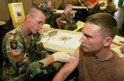 
Spc. Ian Boremski administers an anthrax vaccine to Sgt. Christian Scharfenberg in August at Fort Campbell, Ky. 
 (File/Associated Press / The Spokesman-Review)