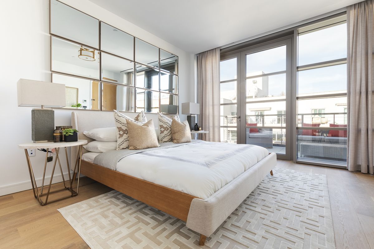 Mirrors are used in a grid as an extension of a low-profile headboard in this master bedroom.  (Courtesy)