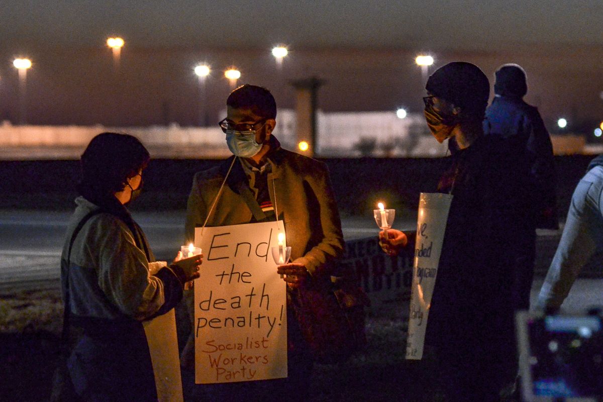 Gabby Prosser, left, and Nick Neeser, right, from Minneapolis, Minn., talk with Samir Hazboun, center, from Louisville, Ky., during a protest against the execution of Brandon Bernard across Prairieton Road from the Federal Death Chamber in Terre Haute, Ind., on Thursday evening, Dec. 10, 2020.  (Austen Leake)