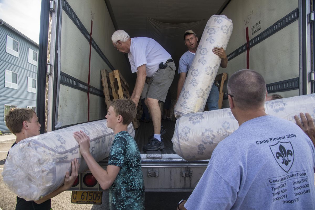 Volunteers unload bedding for the Pope Francis Haven House, July 20, 2017, in Spokane Valley, Wash. The Mormon Church donated 200 bed to the Catholic Charities homeless housing project. (Dan Pelle / The Spokesman-Review)