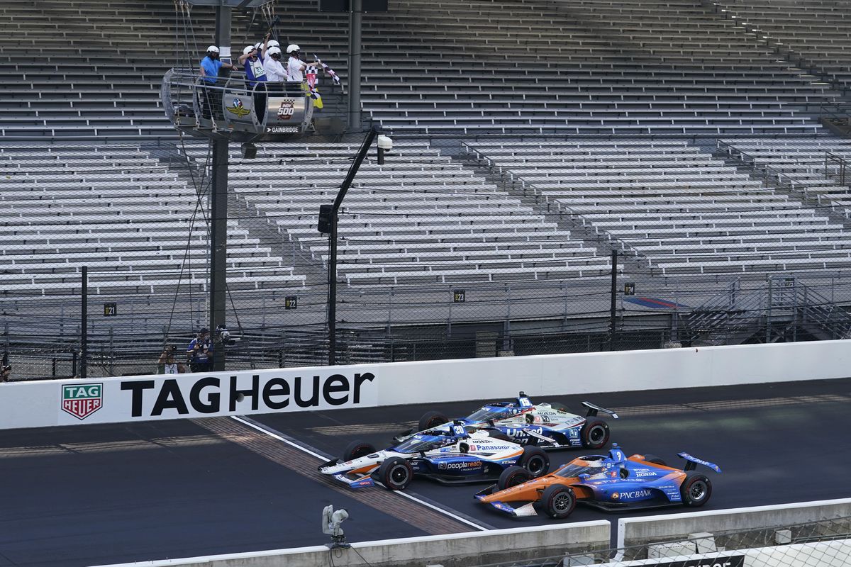 Takuma Sato, middle, of Japan, crosses the start/finish line to win the Indianapolis 500 auto race at Indianapolis Motor Speedway, Sunday, Aug. 23, 2020, in Indianapolis. Scott Dixon, front, of New Zealand, finished second and Graham Rahal, back, finished third.  (Darron Cummings)