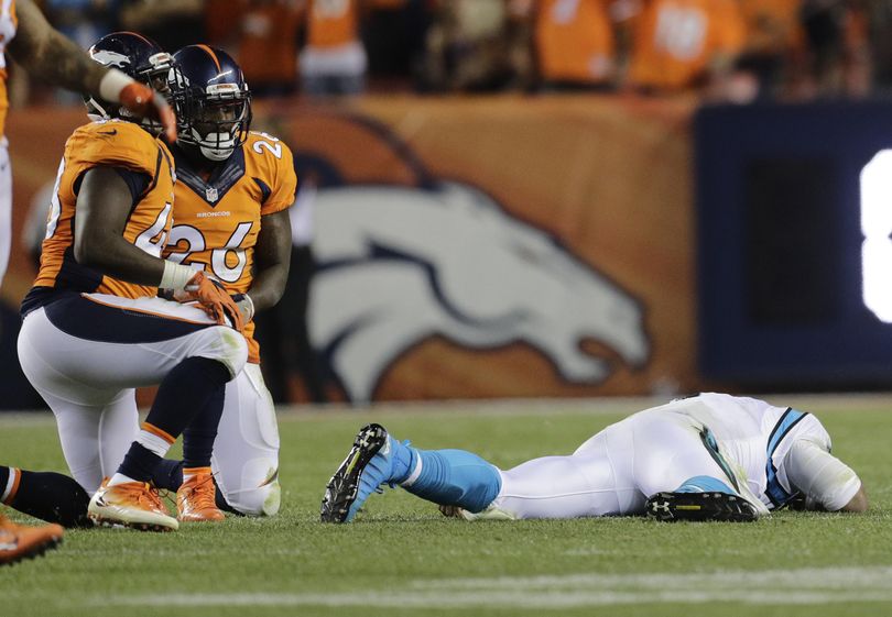 Carolina Panthers quarterback Cam Newton lies on the turf after a roughing the passer penalty on Denver Broncos free safety Darian Stewart (26) during the second half Thursday in Denver. (Joe Mahoney / Associated Press)