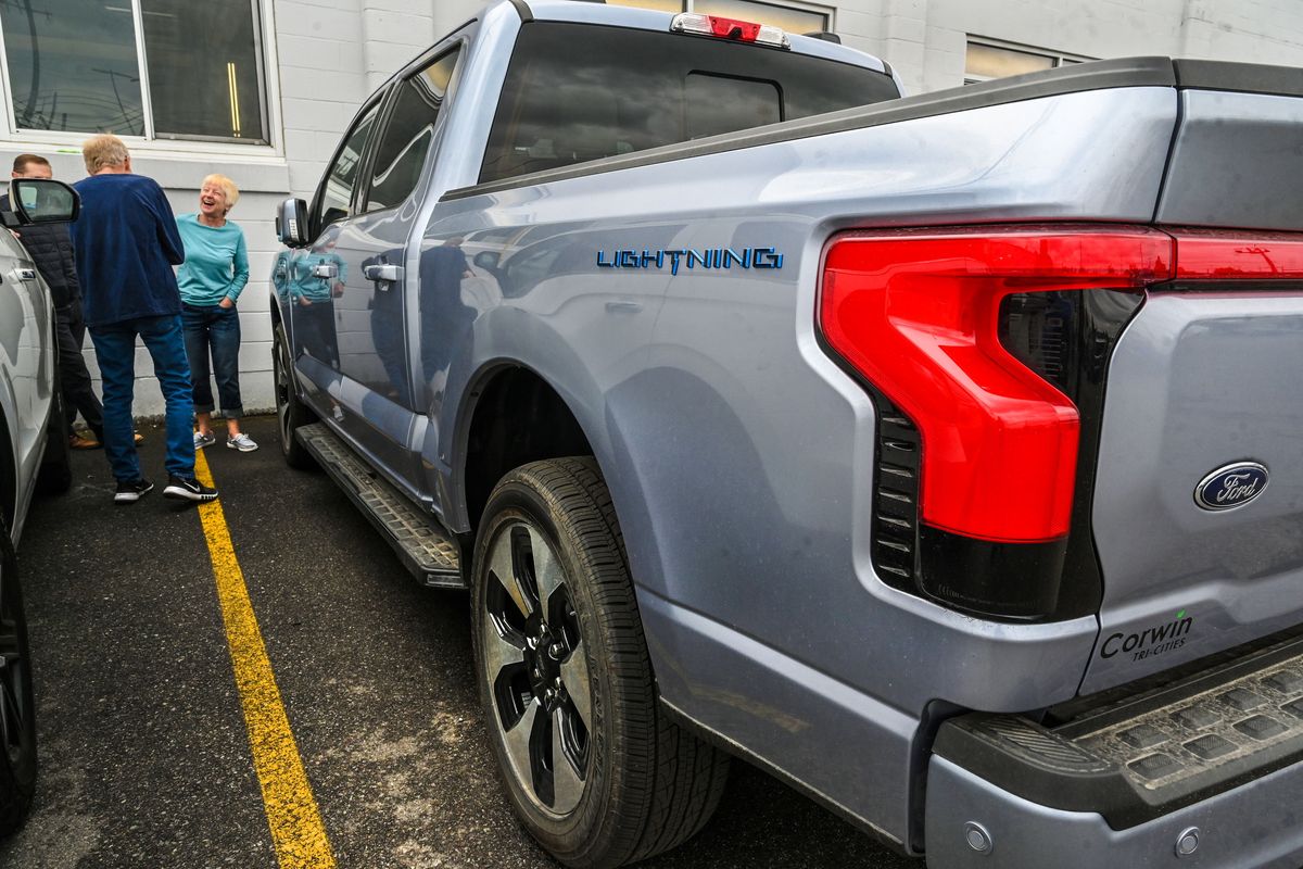 Gerry and Cheryl Szendre, of Spokane, visit with Corwin Ford internet sales manager Ken Galimanis, at left, as they get a close look at Ford Lightning EV on Thursday in Spokane Valley.  (DAN PELLE/THE SPOKESMAN-REVIEW)