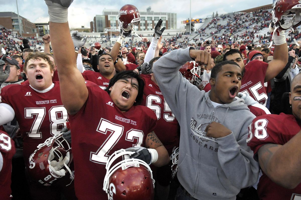 In this Nov. 22, 2008 file photo, WSU players celebrate their Apple Cup victory over rival Washington by singing the fight song to the fans at Martin Stadium in Pullman. (FILE / The Spokesman-Review)